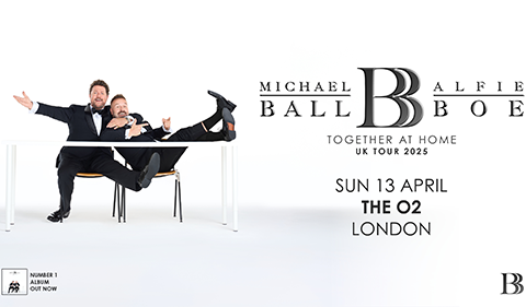 Promotional poster for Michael Ball and Alfie Boe's "Together at Home" UK Tour at The O2 in London. The image features the duo dressed in tuxedos, playfully posing around a white table against a white background. Their names and the tour title are displayed in elegant black text.